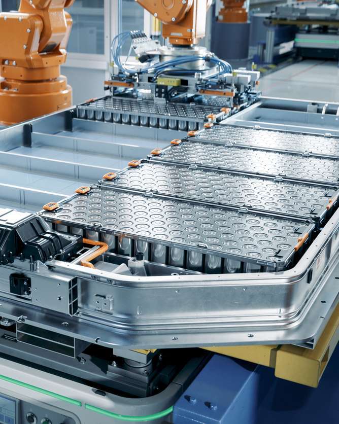 EV Battery Pack on Production Line Equipped with Robot Arms inside Modern Factory. Battery for Automotive Industry. Lithium-ion High-voltage Battery for Electric Vehicle or Hybrid Car Manufacturing